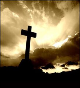 Silhouette of cross against dramatic cloudy sky.